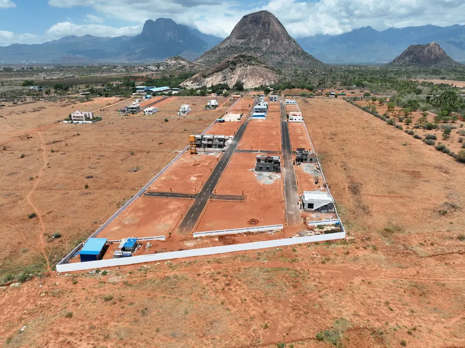 The same plotted development seen along its main access road, with hills across the skyline