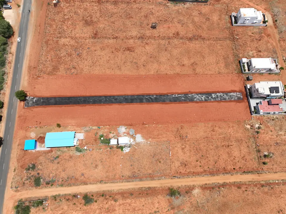 Close aerial view of individual plot boundaries, a kerbed internal road and completed houses